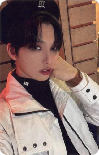 Photocard of Seoho holding a fist to his cheek