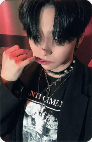 Photocard of Seoho wearing all black and spikes with a cut on his nose, pulling his cheek