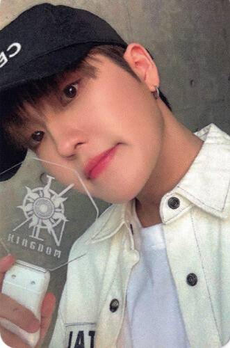 Photocard of Louis wearing a black baseball cap and white shirt, holding a History of Kingdom 7 lightstick by his face