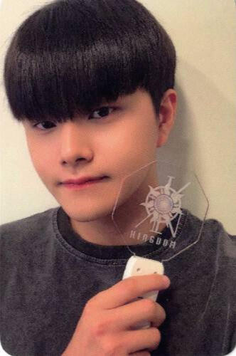 Photocard of Jahan wearing a dark grey t-shirt and holding a History of Kingdom 7 lightstick by his face