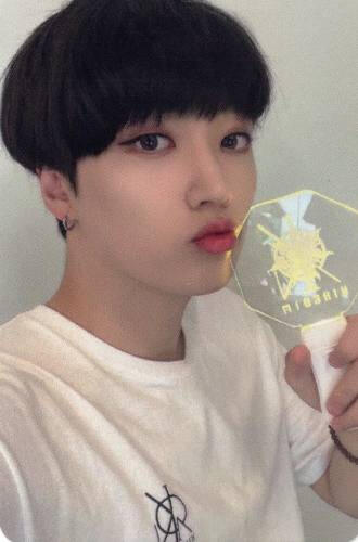 Photocard of Arthur holding the History of Kingdom 7 lightstick by his lips and doing a kissy face