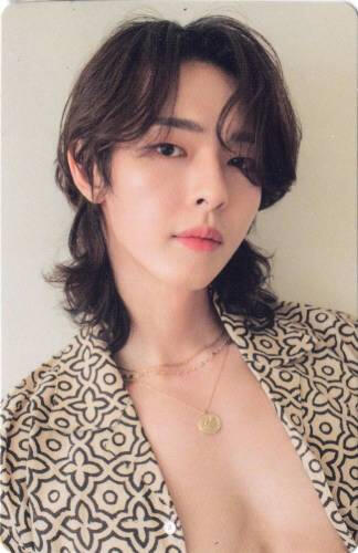 Photocard of Kyubin wearing an open beige shirt and looking into the camera