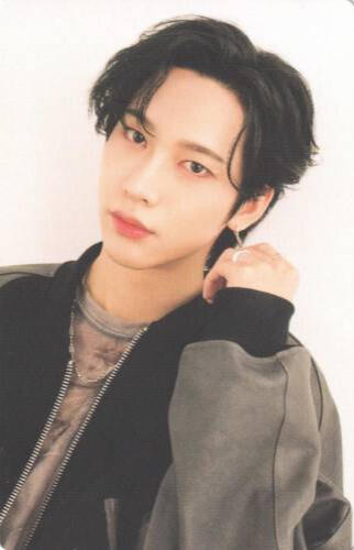 Photocard of Nine wearing a black and grey jacket and holding a hand by his face