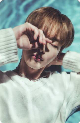 Photocard of Kyubin under water reflections holding a hand in front of his eye