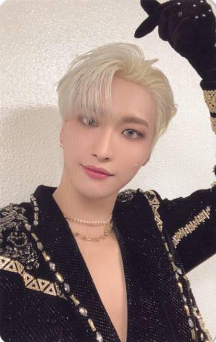 Photocard of Seonghwa wearing a black and gold outfit and making a finger heart