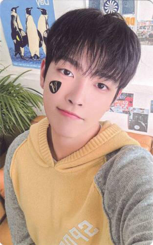 Photocard of Hongjoong smiling with a guitar pick on his cheek