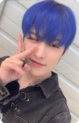 Photocard of Hongjoong with blue hair and a black denim jacket, making a peace sign and winking