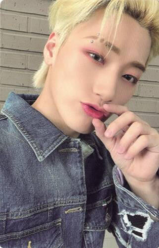 Photocard of San wearing a denim jacket and pinching his lips