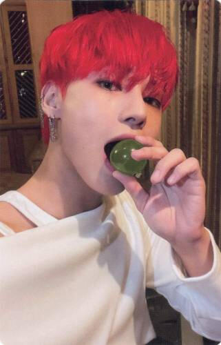 Photocard of Wooyoung pretending to eat a large green orb