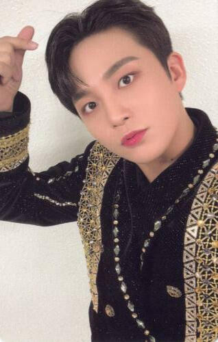 Photocard of Jongho wearing a black and gold outfit and making a finger heart