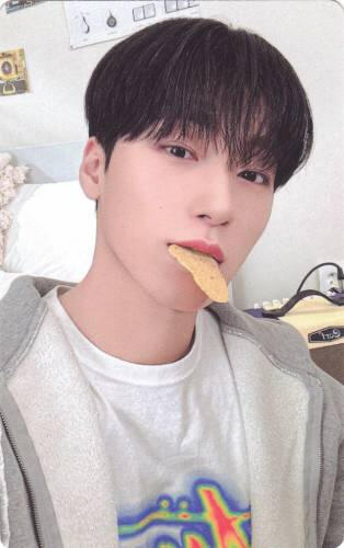 Photocard of San with a cracker in his mouth