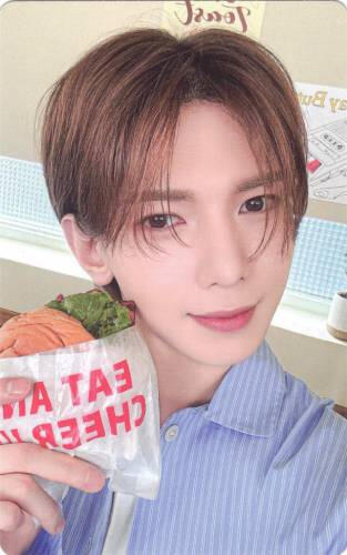 Photocard of Yeosang holding a sandwich by his face