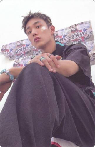 Photocard of Intak sitting and looking down at the camera