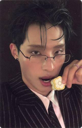 Photocard of Keeho in a suit and glasses about to bite a biscuit
