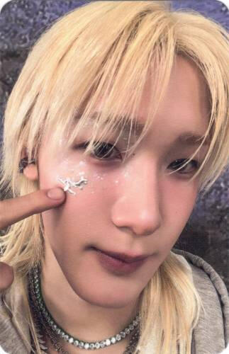 Photocard of Soul close to the camera poking a sticker on his cheek