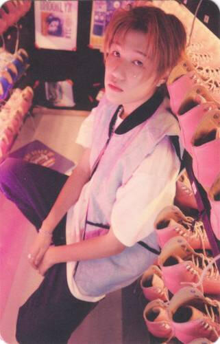 Photocard of Jongseob sitting among racks of roller skates