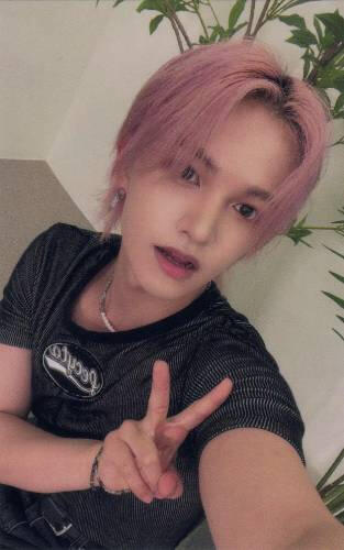 Photocard of Bit with pink hair making a peace sign