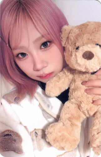 A photocard of Dosie holding a teddy bear