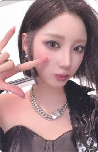 Photocard of Yuki wearing a black outfit and making a "rock on" sign with her hand