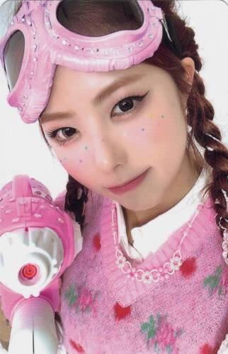 Photocard of Ireh dressed in pink pointing a fake gun at the camera