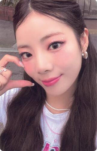 Photocard of Goeun wearing a white shirt and doing a half hand-heart on her cheek