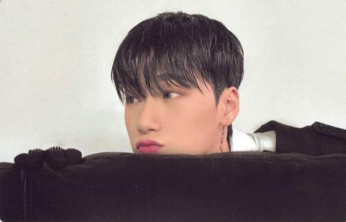 Horizontal photocard of San peeking up from behind a couch