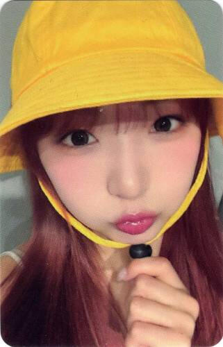 Photocard of Yume wearing a yellow bucket hat and puffing her cheeks