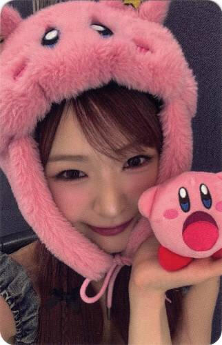 Photocard of Yume smiling while wearing a kirby hat and holding a small kirby plush