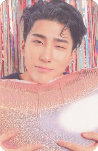 Photocard of Harin winking and holding a heart shaped balloon