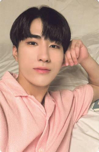 Photocard of Harin laying back and resting his head on his fist