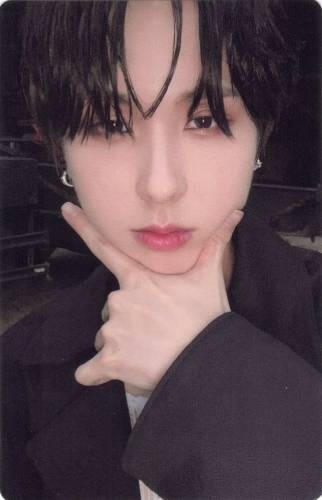 Photocard of Giuk making a check symbol under his chin and staring at the camera