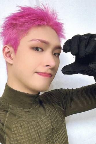 Photocard of Mingi wearing a green athletic shirt and thick black gloves, holding a hand by his face