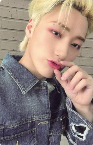 Photocard of San wearing a denim jacket and pinching his lips