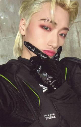 Photocard of San wearing black techwear and shiny black gloves holding a finger gun under his chin