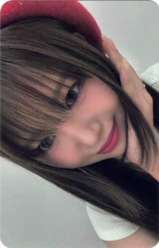 Photocard of Yuna resting her hand on her cheek and smiling