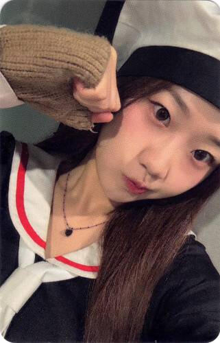 Photocard of Yousom in a sailor outfit making a fist by her cheek