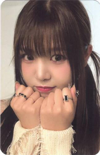 Photocard of Yuna holding two fists to her chin and pouting lightly