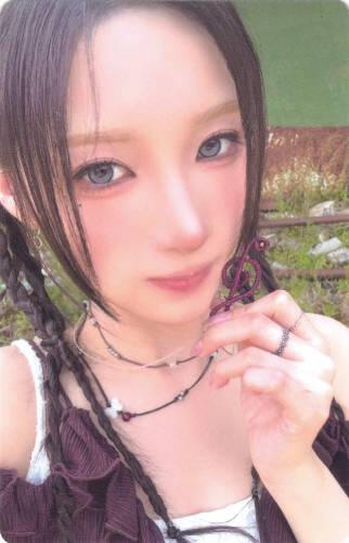 Yuki holding up a music note necklace to the camera