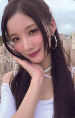 Photocard of Yuki wearing a low-cut white top and holding her face