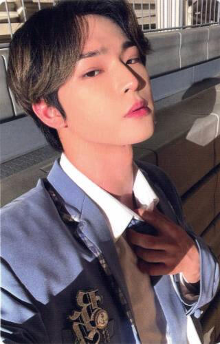 Photocard of Leedo wearing a blue and white school uniform, holding the knot of the tie