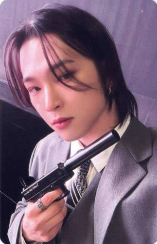 Photocard of Leedo wearing a grey suit and holding a pistol with a silencer
