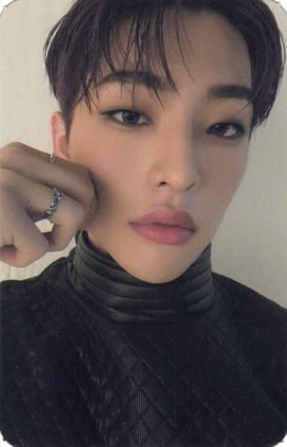 A photocard of Mujin wearing a black outfit and pinching his cheek