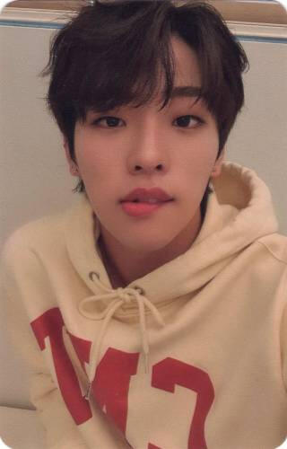 Photocard of Mujin wearing a hoodie and biting his lip
