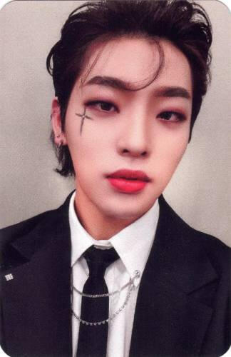 Photocard of Mujin in a suit with a black cross under his eye