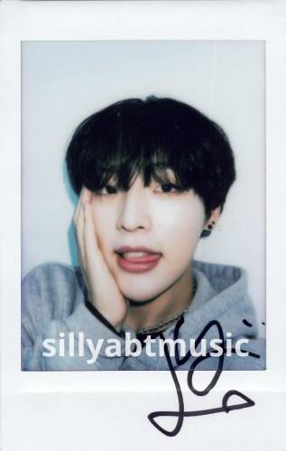 A signed polaroid of Mujin cupping his face and sticking his tongue out