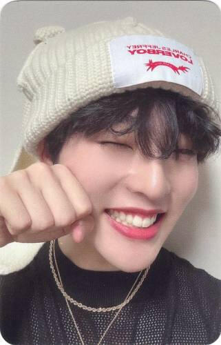 Photocard of Mujin in a bunny ear hat, making a fist by his face, and grinning widely
