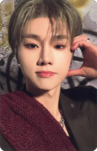 Photocard of Jungsu wearing a black and red suit and making a half hand heart against his cheek
