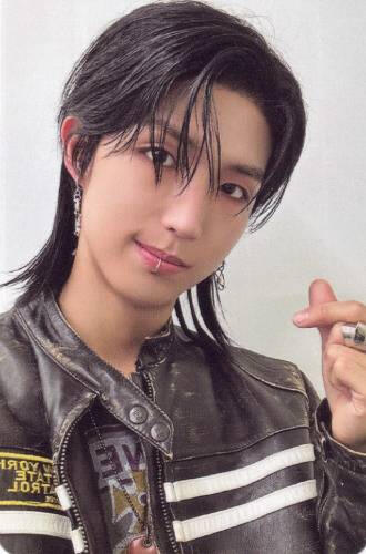 A photocard of Junhan wearing a black racing jacket and making a finger heart