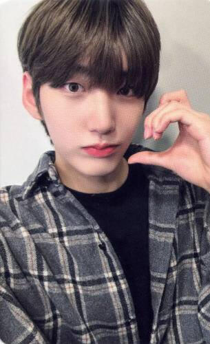 Photocard of Hwon wearing a black flannel making a half-heart with an animal ear with his hand against his cheek
