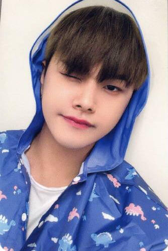 Photocard of Jahan wearing hooded, blue, dinosaur pajamas and winking